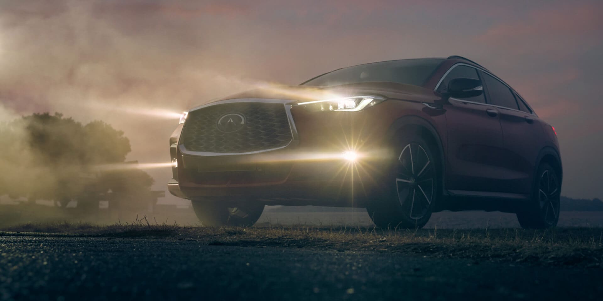 Pre-owned INFINITI SUV shining its headlights through fog